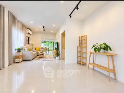 Spacious modern living room with elegant decor and large windows offering natural light.