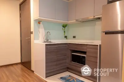 Modern compact kitchen with sleek cabinetry and stainless steel appliances