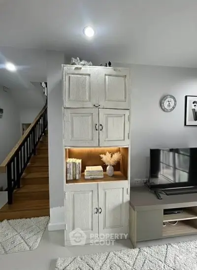 Charming living room with rustic cabinet and modern TV setup, perfect for cozy family gatherings.