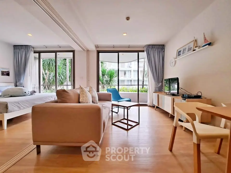 Spacious open-plan living room with modern decor and large windows.