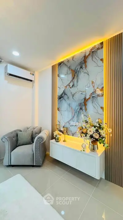 Luxurious living room with elegant marble accent wall and plush armchair