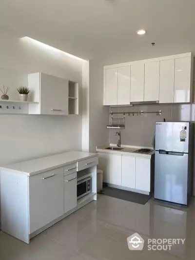 Sleek modern kitchen with white cabinetry, stainless steel appliances, and ample countertop space in a bright, contemporary home.