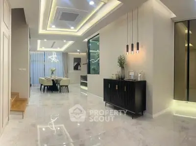 Luxurious modern living room with elegant dining area and stylish lighting fixtures.