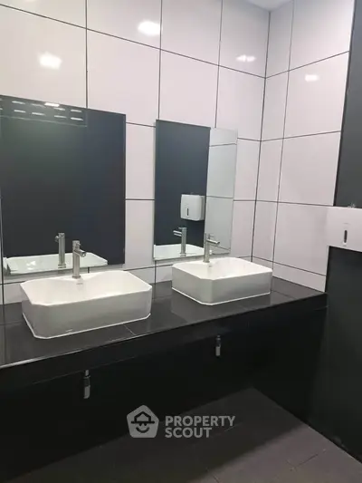 Modern bathroom with dual sinks and sleek tile design, perfect for contemporary living.