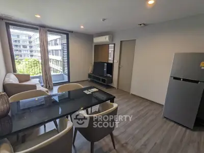 Modern living room with dining area and balcony view in a stylish apartment.