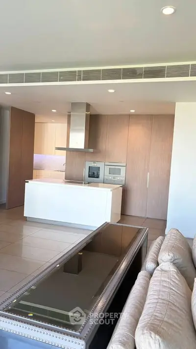 Modern open kitchen with sleek appliances and stylish living area in luxury apartment.