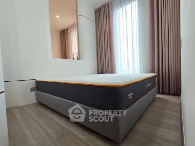 Modern bedroom with large window and stylish curtains, featuring a comfortable bed and sleek flooring.