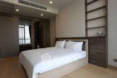 Modern bedroom with stylish wooden accents and large bed in a contemporary apartment.
