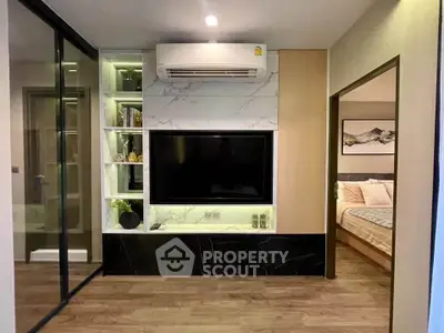 Modern living room with sleek TV setup and adjacent cozy bedroom