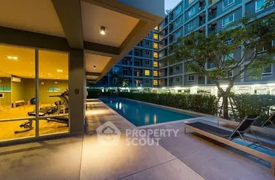 Modern apartment complex with pool and gym facilities at dusk