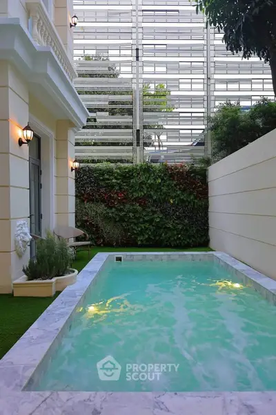 Luxurious private pool in elegant courtyard with lush greenery and modern architecture.
