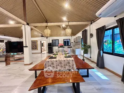 Spacious open-plan living and dining area with modern kitchen and elegant decor.