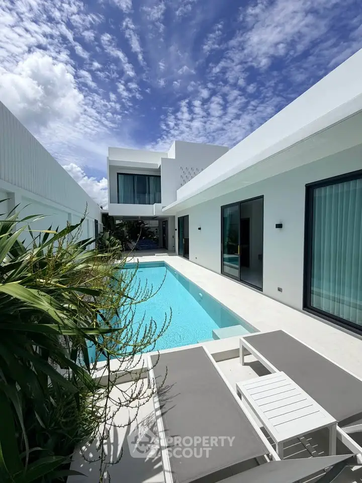 Luxurious modern villa with private pool and sleek architectural design under a vibrant blue sky.