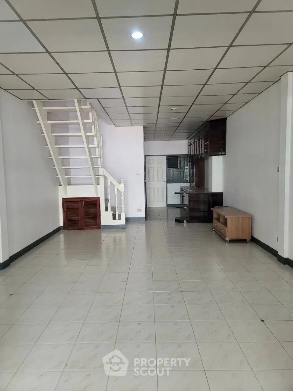 Spacious open-plan living area with staircase and tiled flooring