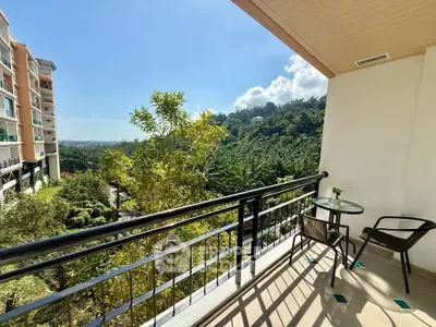 Spacious balcony with scenic view of lush greenery and modern buildings, perfect for relaxation.