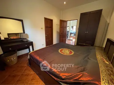 Spacious bedroom with elegant decor and ample natural light, featuring a large bed and stylish furniture.