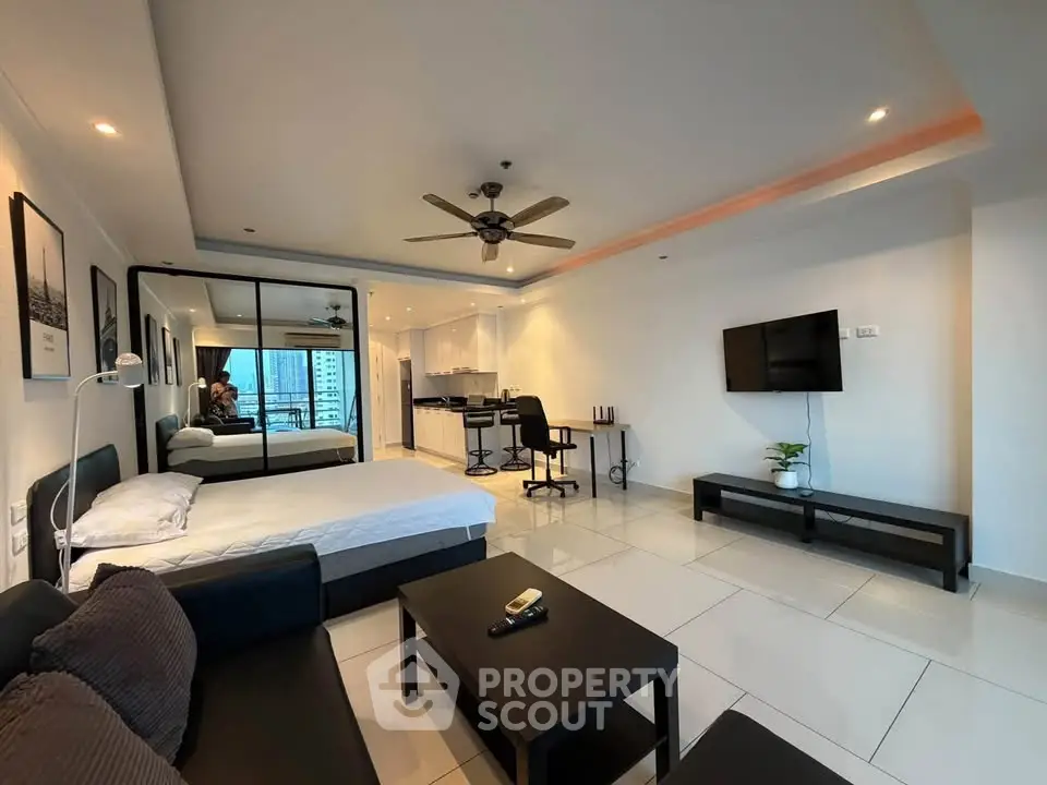Spacious modern studio apartment with open layout and city view, featuring sleek furnishings and contemporary design.