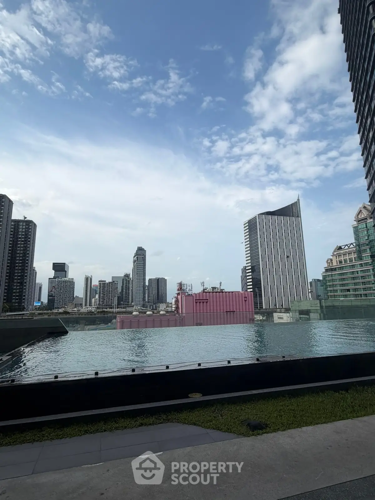 Stunning cityscape view from a modern rooftop pool with skyscrapers in the background.