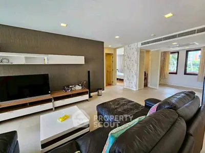 Spacious modern living room with leather sofa and entertainment center