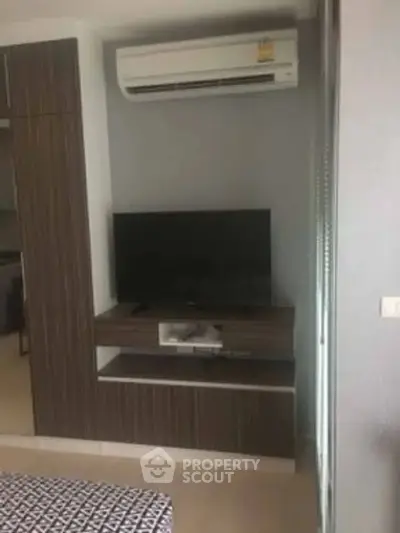 Modern living room with air conditioning and TV unit in stylish apartment.