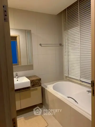 Modern bathroom with bathtub and sleek vanity in elegant home
