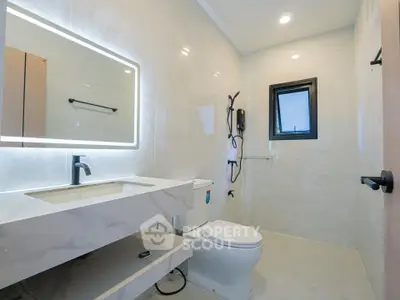 Modern bathroom with sleek fixtures and illuminated mirror