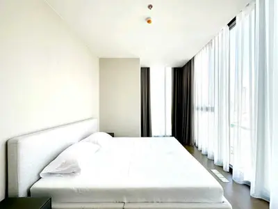 Spacious modern bedroom with floor-to-ceiling windows and minimalist design.
