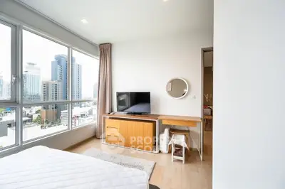 Modern bedroom with city view, large windows, and stylish furniture in a high-rise apartment.