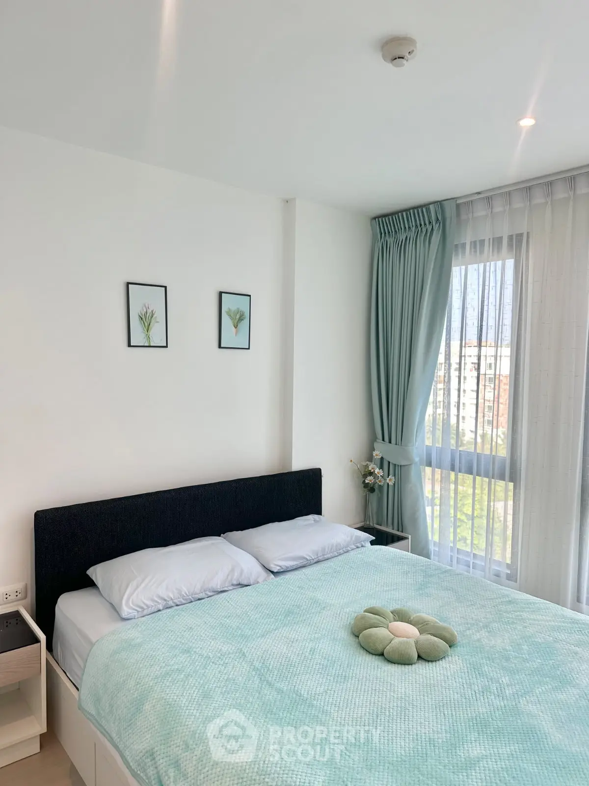 Bright and cozy bedroom with large window and modern decor in a stylish apartment.