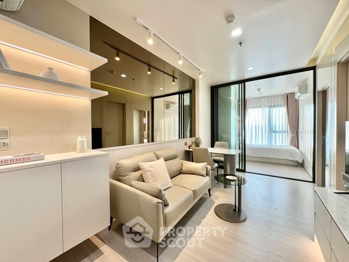 Modern open-plan living room with stylish furniture and bedroom view, perfect for urban living.