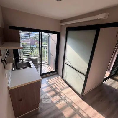 Compact kitchen with balcony access and natural light