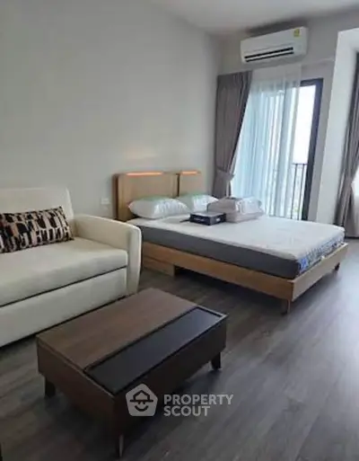 Modern bedroom with stylish decor and natural light, featuring a cozy bed and elegant furnishings.