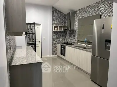 Modern kitchen with sleek appliances and stylish backsplash