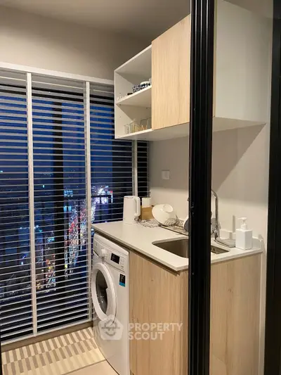 Modern compact kitchen with washing machine and city view