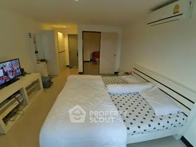 Spacious bedroom with modern furnishings and air conditioning in a cozy apartment.