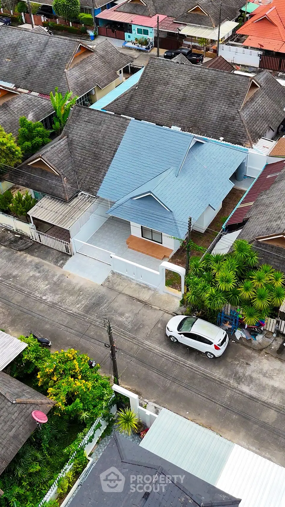 Charming suburban house with blue roof and driveway in a peaceful neighborhood.