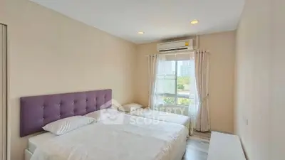 Spacious bedroom with large window and modern decor in a bright apartment.