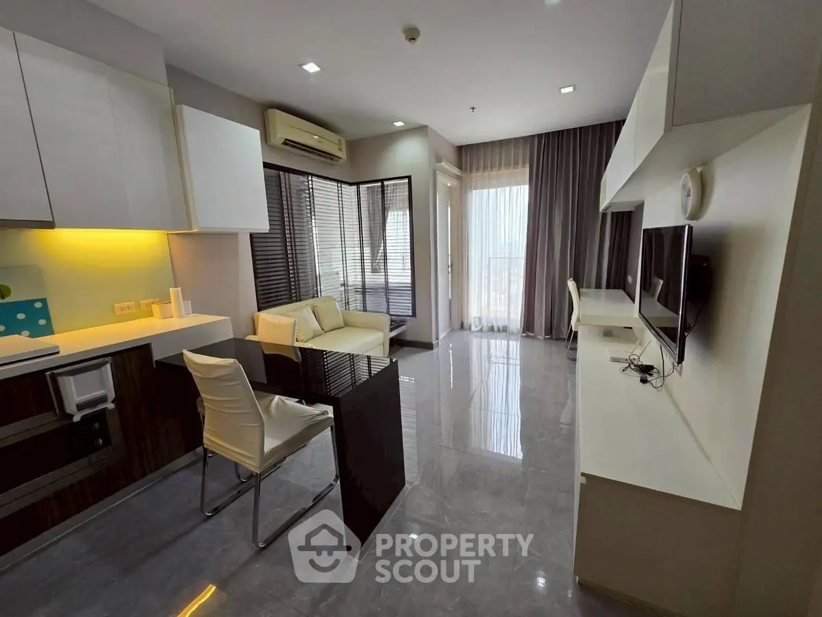 Modern living room with sleek furniture and open kitchen layout, featuring a bright and airy atmosphere.