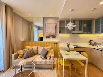 Modern open-layout living room and kitchen with stylish decor and natural light.