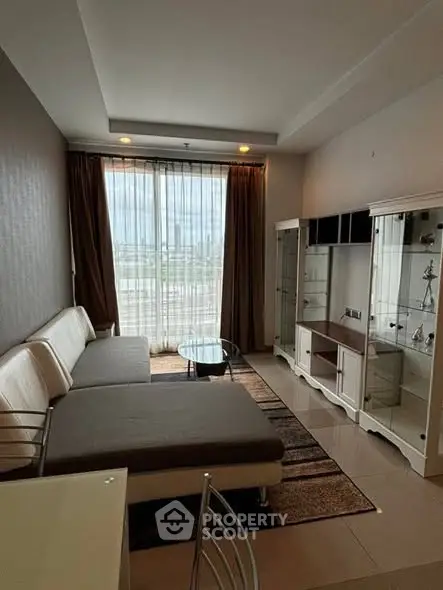 Modern living room with large windows and stylish furniture, offering a bright and inviting atmosphere.