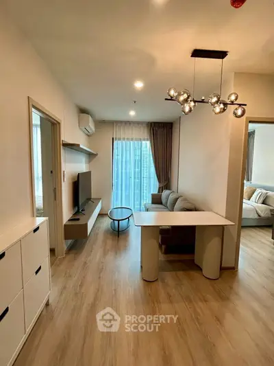 Modern living room with stylish decor and open layout, featuring a cozy sofa and elegant lighting.