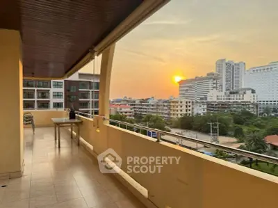 Spacious balcony with stunning sunset view in urban setting, perfect for relaxation.