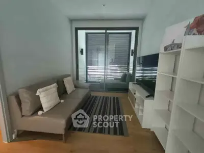 Modern living room with sleek sofa, TV, and stylish decor in a cozy apartment setting.