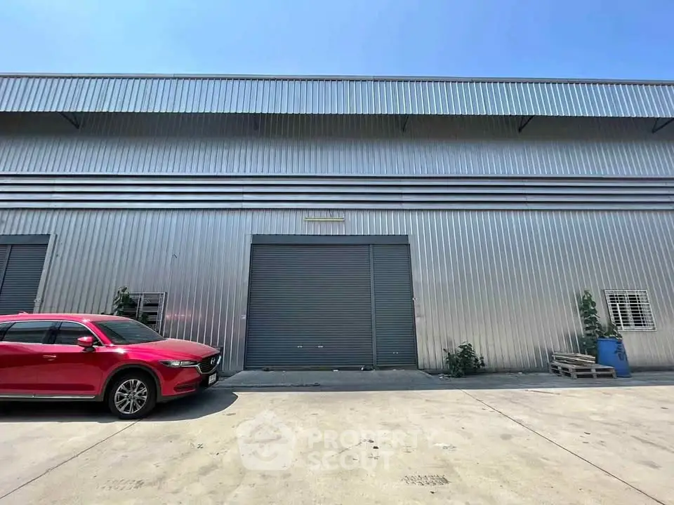 Industrial warehouse exterior with metal siding and large roller door