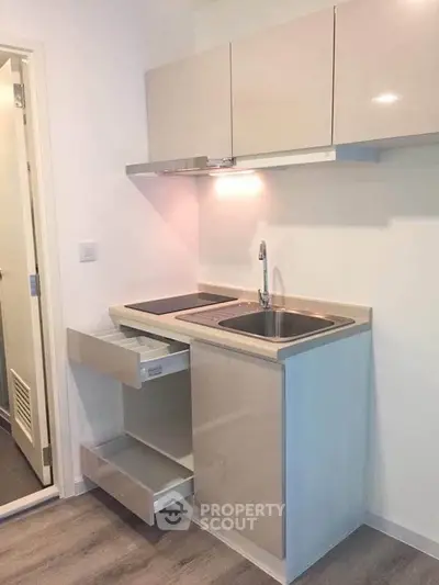 Compact modern kitchen with sleek cabinetry and integrated appliances in a cozy apartment.