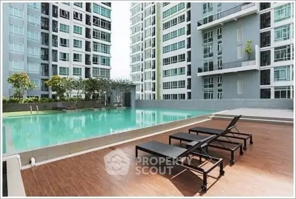 Luxurious condominium pool area with modern lounge chairs and stunning high-rise backdrop.