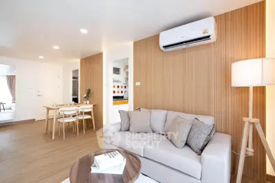 Modern living room with cozy sofa, dining area, and stylish decor in a bright apartment.