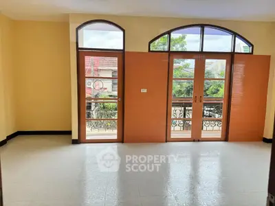 Spacious room with large windows and balcony access, perfect for natural light lovers.