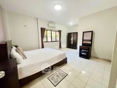 Spacious bedroom with modern furniture and large window for natural light