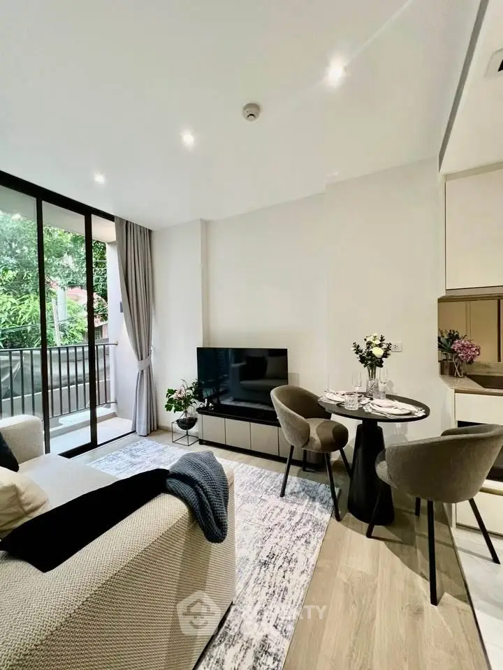 Modern living room with elegant decor and balcony view, featuring cozy seating and stylish dining area.
